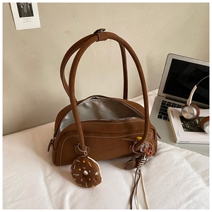 Brown vintage Boston bag detail with white stitching, plush charm and tassel accent