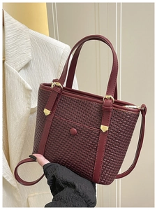 Dettaglio della borsa tote bordeaux con trama intrecciata e finiture in metallo dorato