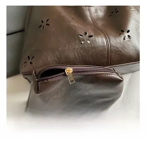 Vue détaillée du sac en similicuir marron avec découpes florales et fermeture dorée
