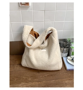 Detail of cream sherpa tote bag showing the OUR FAVE label and caramel fabric lining