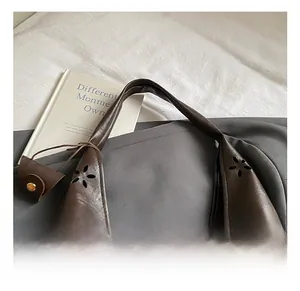 Détails de motifs floraux découpés au laser sur un sac hobo en cuir marron foncé chic