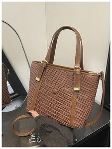 Dettaglio borsa tote intrecciata color caramello con manici in pelle e finiture oro