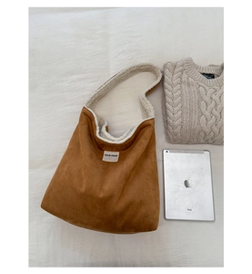Flat lay of brown suede tote bag with white fleece lining and spacious interior