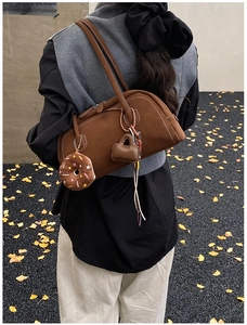 Detail view of a retro brown suede Boston shoulder bag with cute hanging charms