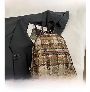 Détail du sac à dos vintage à carreaux marron en tweed avec poche zippée dorée