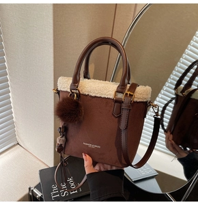 Vue détaillée du sac seau en daim marron avec garniture en fausse fourrure et boucles dorées