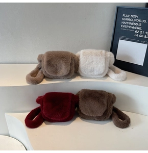 Faux fur crossbody bags in beige, white, burgundy, and brown colors on display stand