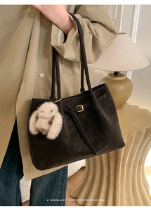 Detail of dark brown matte tote bag with minimalist retro vibe and plush rabbit charm