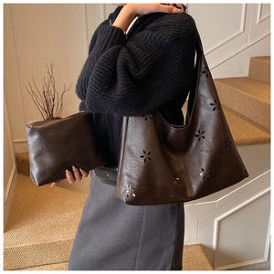 Détails des motifs floraux découpés au laser et pochette assortie du sac à main café