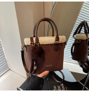 Détail du sac seau en daim marron avec bordure en peau lainée et pompon moelleux