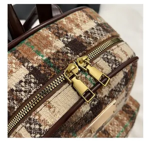 Vue détaillée des fermetures éclair dorées et de la texture en tweed du sac à dos