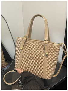 Dettaglio della borsa tote intrecciata con finiture in finta pelle kaki e fibbia d'oro
