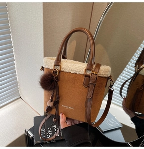 Détail du sac seau en daim marron avec bordure en fausse fourrure blanche et pompon