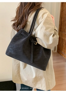 Grand sac cabas noir mat minimaliste porté avec un trench-coat kaki de style rétro chic