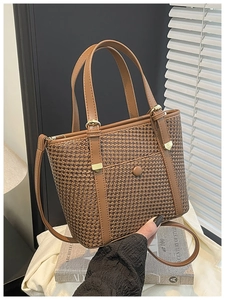 Dettaglio della borsa tote intrecciata marrone con fibbie dorate e tracolla regolabile