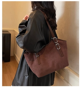 Dettaglio borsa tote in pelle scamosciata marrone scuro con tracolla indossata da modella