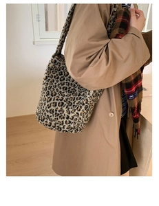 Détail d'un sac cabas en peluche à motif léopard avec une texture douce dans un décor épuré