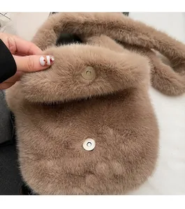 Detail of soft brown plush handbag featuring secure round metal magnetic buckle closure
