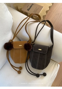 Detailed view of vintage bucket bags in mustard and dark brown with decorative pom-poms