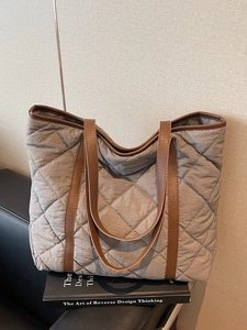 Minimalist grey quilted tote bag with brown faux leather handles for daily commute