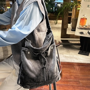 Detailed close-up of retro washed denim crossbody bag featuring metal buckle and zipper