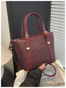 Dettaglio della borsa tote bordeaux in pelle PU intrecciata con fibbia metallica fine