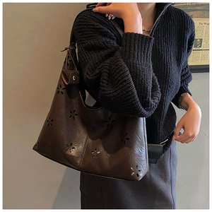 Détail du motif floral découpé au laser sur le sac cabas en cuir marron foncé