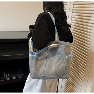 Detail of grey canvas tote bag featuring vibrant colorful patterned sychano shoulder strap