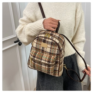 Détail du sac à dos vintage en tweed écossais avec lanières en cuir marron