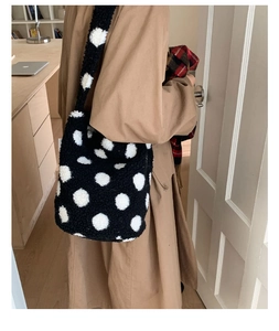 Vue détaillée du sac seau en peluche à grands pois blancs sur tissu en fausse fourrure noire