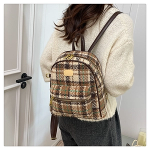 Vue arrière d'un mannequin portant un sac à dos en tweed à carreaux et lanières en cuir