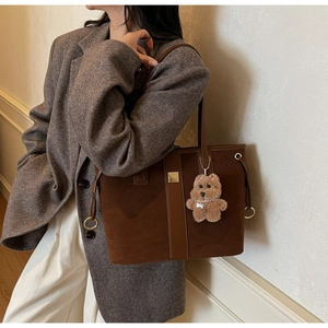 Brown suede tote bag with leather straps, square buckle, and cute plush dog charm