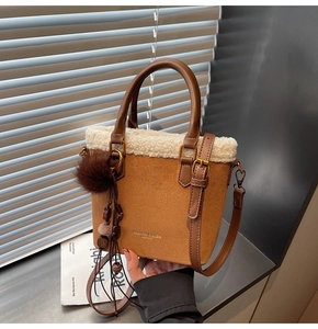 Détail du sac seau en daim marron avec garniture en peau de mouton et breloque pompon