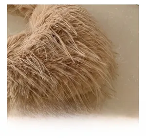 Détail de la texture en fausse fourrure camel du sac à bandoulière chic en forme de cœur