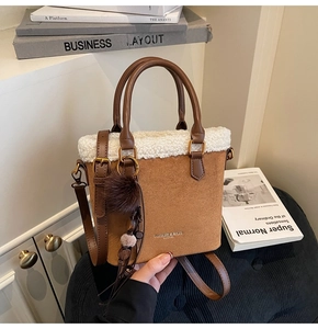 Détail du sac seau en daim avec garniture en fausse fourrure blanche et pompon