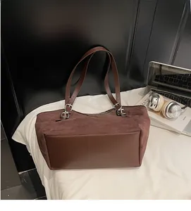 Dettaglio borsa tote marrone scuro in finto camoscio e pelle con spalline regolabili
