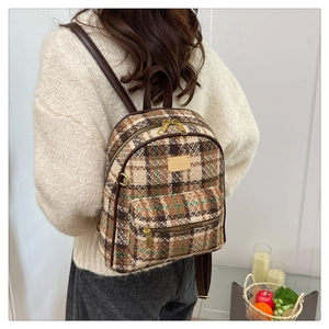 Détail du sac à dos vintage en tweed à carreaux avec bretelles en cuir marron sur modèle