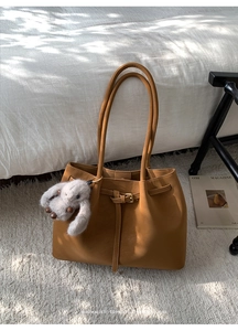 Détail du sac cabas en daim caramel avec boucle décorative et breloque lapin en peluche