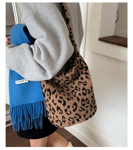 Détail du sac seau léopard en peluche et écharpe en laine bleue avec étiquette 100%