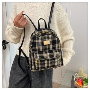 Détail d'un mini sac à dos à carreaux avec garniture en cuir et boucles dorées