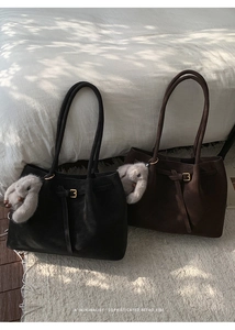Close-up of minimalist retro tote bags in black and coffee with rabbit charms