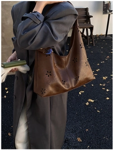 Détail du motif floral découpé au laser sur le sac cabas en cuir marron pour femme