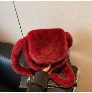 Close-up of fluffy burgundy faux fur shoulder bag texture with round flap design