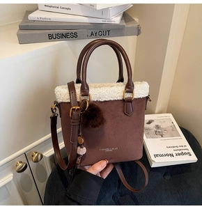 Détail du sac seau en daim marron avec bordure en peau de mouton blanche et pendentifs