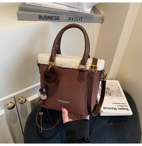 Détail du sac seau vintage en daim marron avec bordure en fourrure et breloque perlée