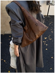 Détails des motifs floraux découpés au laser sur un sac cabas vintage marron foncé