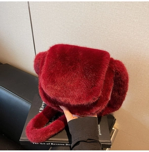 Detailed view of luxury burgundy faux fur shoulder bag with soft plush flap closure