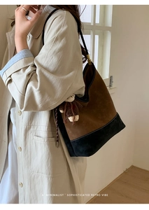 Borsa tote bicolore con ciondolo a forma di orso, indossata a spalla dalla modella