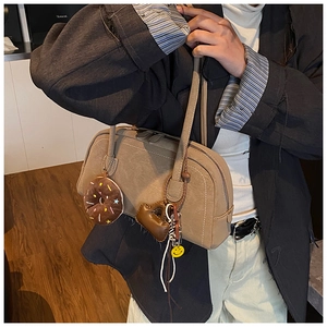 Khaki Boston shoulder bag with decorative cute charms styled on a black blazer outfit