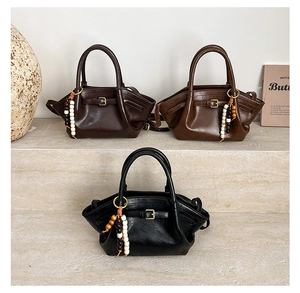 Three leather handbags in black, tan and brown with wood bead tassels and metal hardware